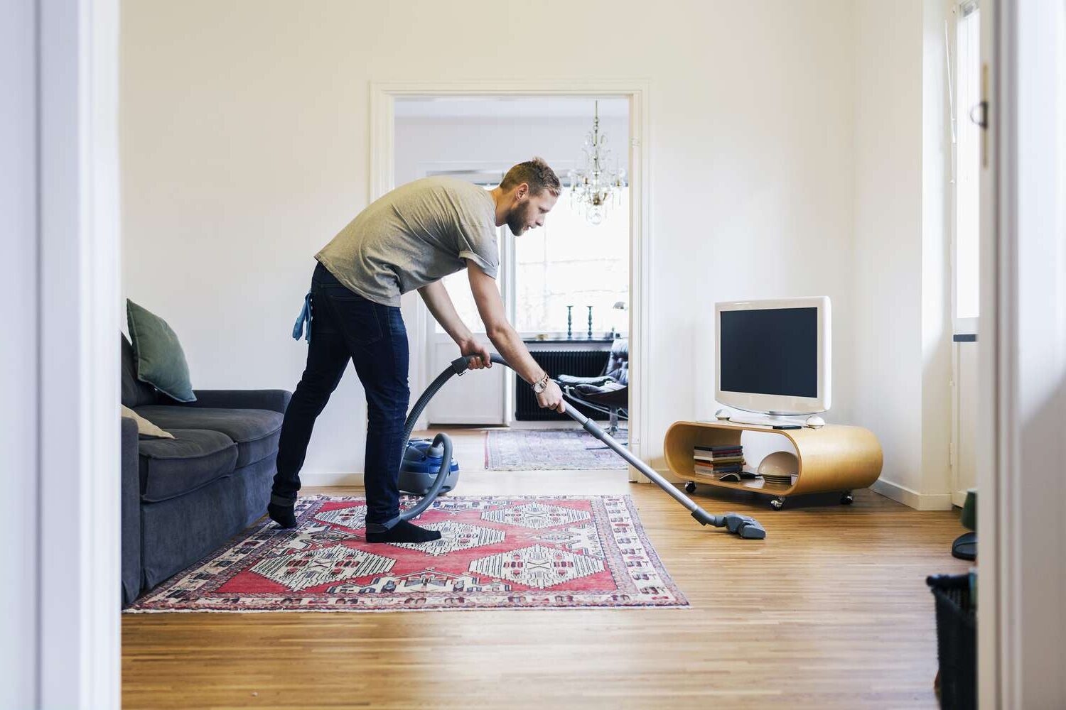 side-view-of-man-vacuuming-hardwood-floor-562452123-5a0326d4e258f800370fa3ca
